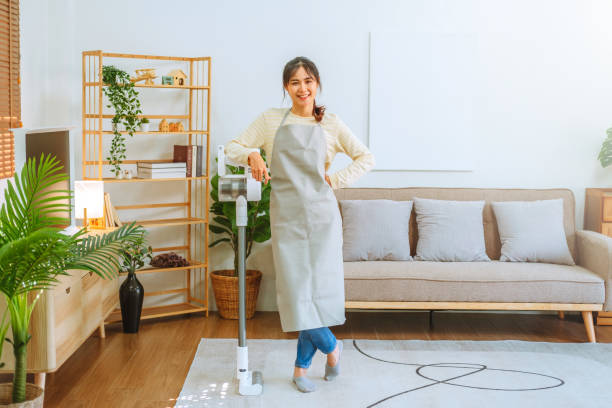 Asian woman using vacuum machine cleaning the floor. housekeeping concept